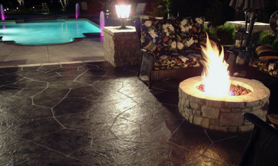Decorative backyard patio with built in fire pit and in ground pool.