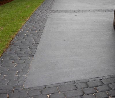 Textured plain gray concrete driveway with stamped concrete borders.