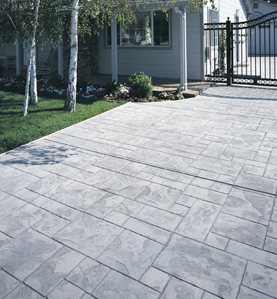 Light gray stamped concrete patio made to look like various sized pavers.