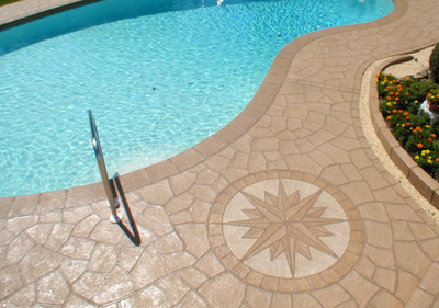Stamped concrete pool deck with decorative detailed stamp that looks like a compass.