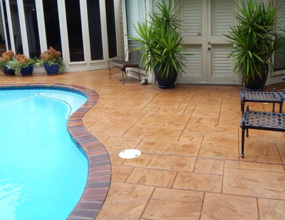 Decorative concrete pool deck with brick stamped edging.